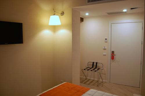 a bedroom with a bed and a chair and a light at La Corte Fiorita Como in Como