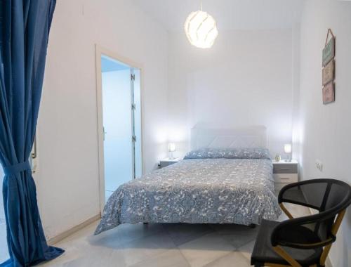 1 dormitorio con cama y cortina azul en Casa Santa Clara Street, en Sevilla