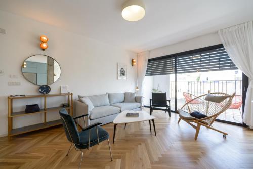 a living room with a couch and a table and chairs at Beach Apartments TLV in Tel Aviv