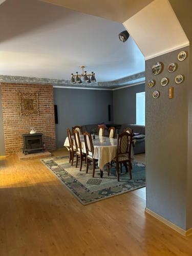a dining room with a table and chairs and a fireplace at Opushka in Vorobʼyëvka