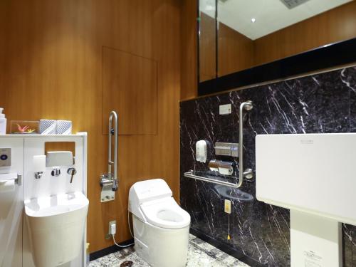 a bathroom with a toilet and a sink at APA Hotel Shizuoka-eki Kita in Shizuoka