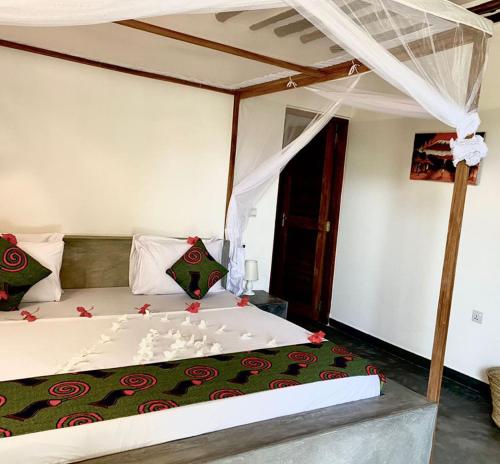 a bedroom with a large bed with a canopy at Diana Place in Paje