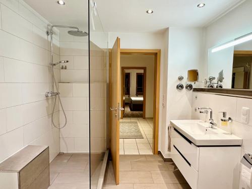 ein Badezimmer mit Dusche und Waschbecken in der Unterkunft LIKE HOME, cozy apartment, 2 bedrooms, Netflix, 55" TV, balcony, parking, self-check-in in Penzberg