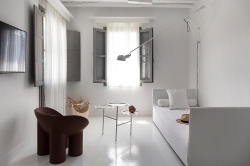 a living room with a table and a chair at ANEMI Folegandros in Karavostasi