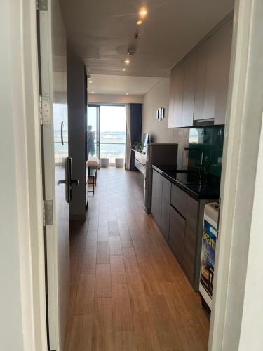 a kitchen with wooden floors and a view of a room at Citadines House - seaview & balcony - studio apartment in Ha Long