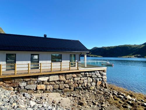 a house on a lake with a dock at Beachfront Paradise Lofoten in Bøstad
