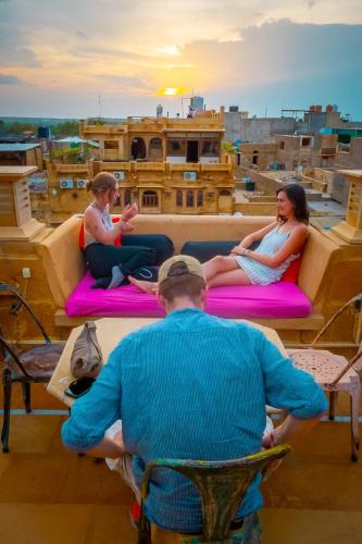 un gruppo di persone seduti su cuscini su un tetto di Open Road Hostel and Cafe a Jaisalmer