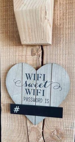 a heart with a sign on a wooden wall at Prachtige vakantiewoning met weids uitzicht in Maldegem