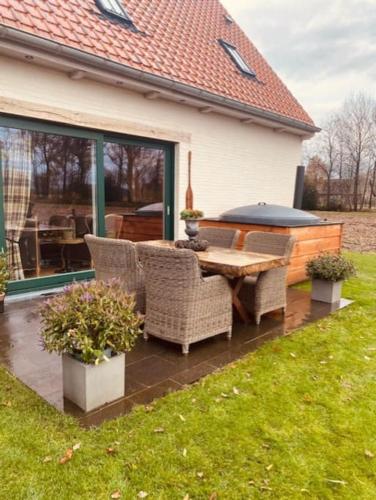 a patio with a table and chairs in a yard at Prachtige vakantiewoning met weids uitzicht in Maldegem