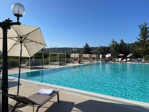 una gran piscina con una silla y una sombrilla en FLOATING SEA HOUSE AURORA, en Portorož