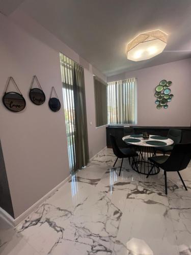 a living room with a table and chairs on a marble floor at Floral Boutique Hotel in Pleven