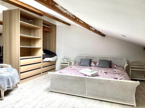 1 dormitorio con 1 cama blanca de mimbre en LES VIEUX PLATANES en La Crau