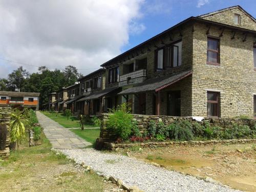 an old brick house with a pathway in front of it at Himalayan Deurali Resort in Pokhara