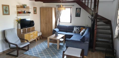 a living room with a blue couch and a staircase at Casa Izvorul Rarăului in Câmpulung Moldovenesc