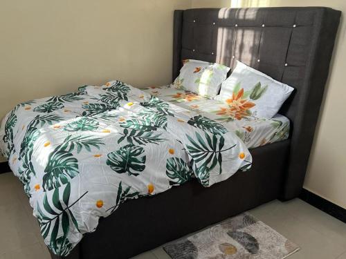 a bed with a black headboard with leaves and oranges at Mima's Apartment in Dar es Salaam