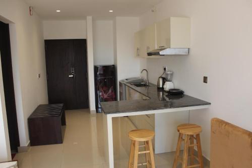 a kitchen with a counter and two bar stools at Ocean Breeze Sea View Luxury Apartments in Negombo
