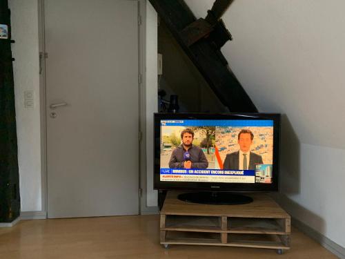 a television sitting on a stand in a room at Le nid d’aigles in Dole