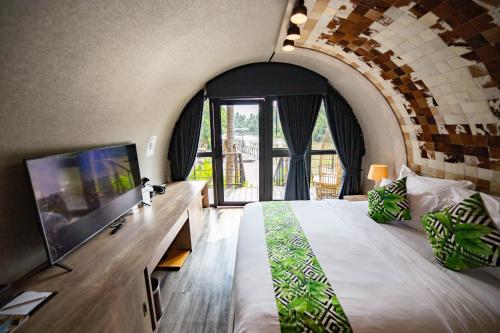 a bedroom with a large bed and a large window at DAMNERNPAWA in Bang Khon Thi