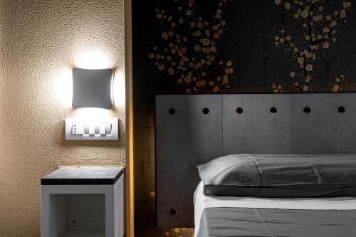 a bedroom with a bed and a lamp on a wall at Ukiyo Suites And Rooms in Cagliari