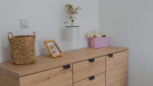 a wooden dresser with two plants on top of it at Apartmani Bubamara Leskovac in Leskovac
