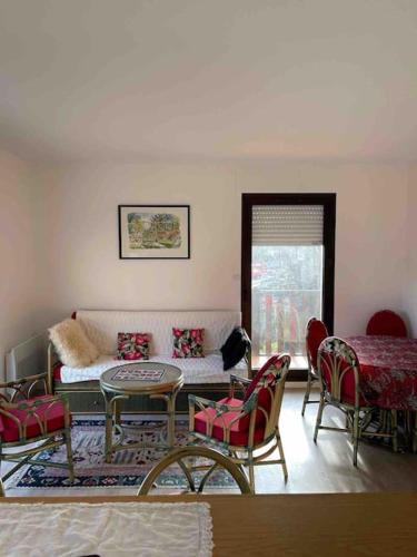 un salon avec un canapé, une table et des chaises dans l'établissement Très bel appartement de Standing a 300 mètres de la mer, et à proximité du casino de Deauville, à Tourgéville
