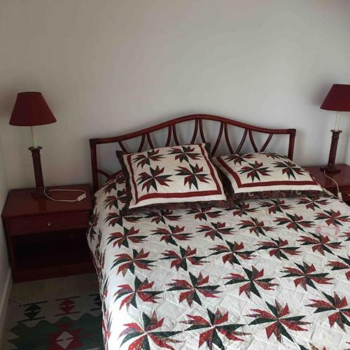 un lit avec deux oreillers dessus dans une chambre dans l'établissement Très bel appartement de Standing a 300 mètres de la mer, et à proximité du casino de Deauville, à Tourgéville