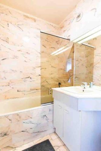 une salle de bain avec une baignoire, un lavabo et une douche dans l'établissement Très bel appartement de Standing a 300 mètres de la mer, et à proximité du casino de Deauville, à Tourgéville