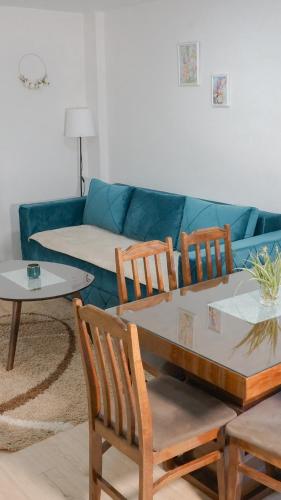 a living room with a couch and a table and chairs at Apartmani Bubamara Leskovac in Leskovac