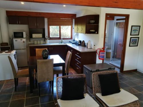 a kitchen with a table and chairs and a kitchen with a counter at Paradise Beach House in Clareport