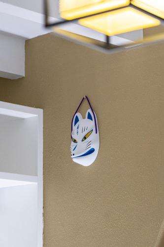 a cat mask on the wall of a room at Ukiyo Suites And Rooms in Cagliari