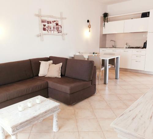 - un salon avec un canapé brun et une table dans l'établissement Sunset house Cabo Verde, à Santa Maria