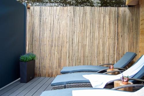 a patio with chairs and a wooden fence at Wellnessoase mitten in Triberg in Triberg