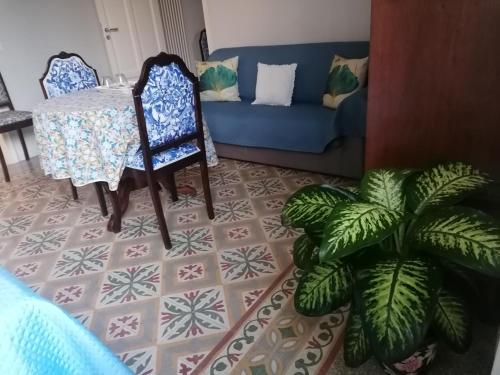 a living room with a table and a blue couch at Battisti 18 Vintage Rooms in Palermo