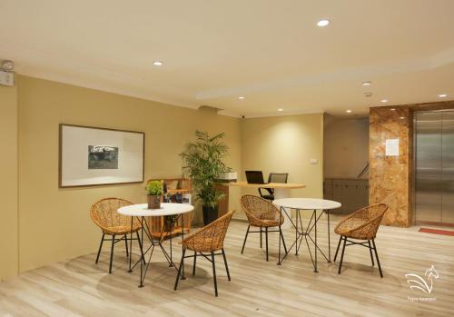 a room with two tables and chairs and a kitchen at Pegasy Apartments & Travel in Hanoi