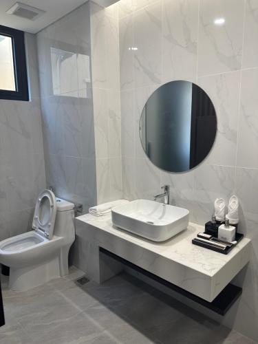 Baño blanco con lavabo y espejo en WYNDHAM LYNN TIMES THANH THỦY - KHU NGHỈ DƯỠNG KHOÁNG NÓNG, en Phú Thọ
