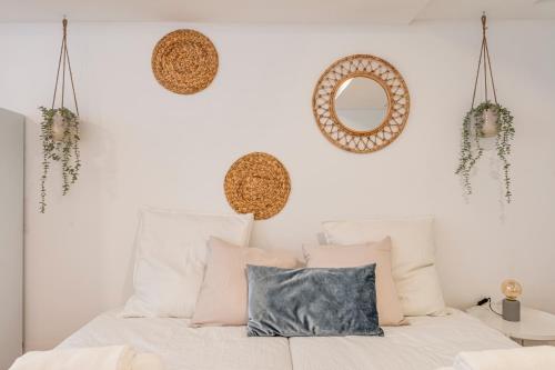 a bedroom with a bed with pillows and a mirror at Chalet Marias - Parede beach apartments in Parede
