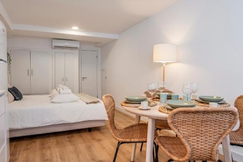 a dining room with a table and chairs and a bed at Chalet Marias - Parede beach apartments in Parede