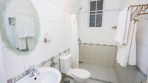 Baño blanco con aseo y lavamanos en Bluefield Cottage - Nuwara Eliya, en Nuwara Eliya