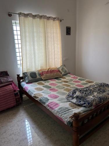 a bedroom with a bed with a curtain and a window at Sambrama in Bangalore