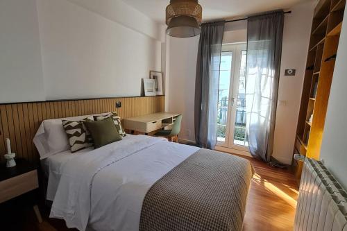 ein Schlafzimmer mit einem großen Bett und einem Fenster in der Unterkunft Rosa de Ciudad. Chalet céntrico con mucha intimidad in Santander