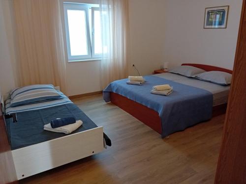 a bedroom with two beds and a window at Spajić Apartments in Seget Vranjica