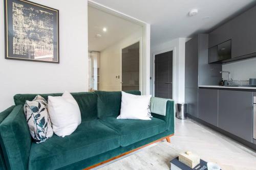 a green couch with pillows in a living room at Chic Central Reading 1BR Apt CHRL F2 in Reading