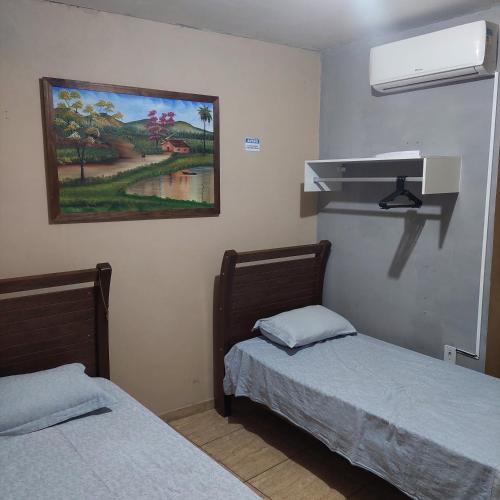 um quarto com duas camas e um quadro na parede em Flat estação em Juazeiro do Norte