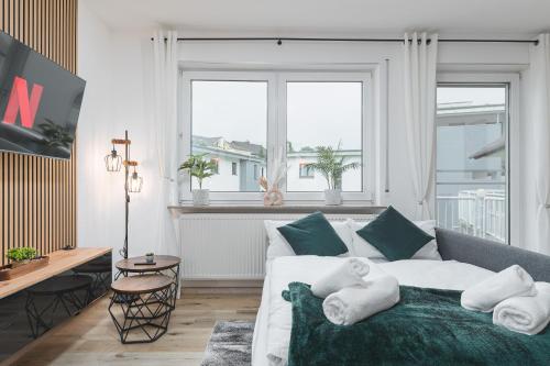 a living room with a white couch and a large window at Roomfall Apartment Sinsheim mit TG & Wi-Fi & Balkon in Sinsheim