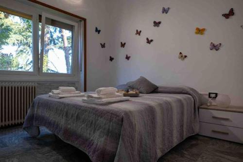 1 dormitorio con 1 cama con mariposas en la pared en Noemi House en Rapallo