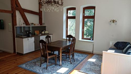 a dining room with a wooden table and chairs at Herrenhaus Harmshagen in Testorf-Steinfort