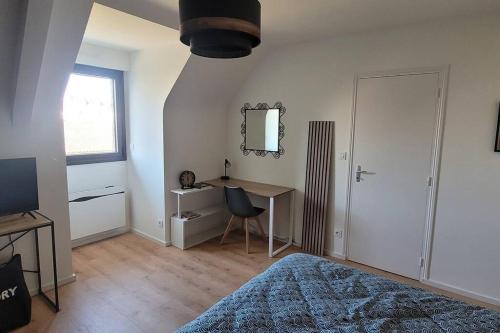 une chambre avec un lit, un bureau et un miroir dans l'établissement Longère en pierre - 5 personnes, à Plouhinec