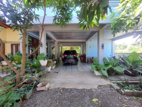 a truck parked inside of a garage with plants at D'Ru Guest House in Labuan Bajo