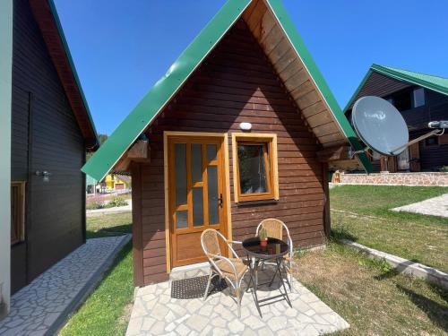 a small house with a table and chairs outside at Small house Floki in Žabljak