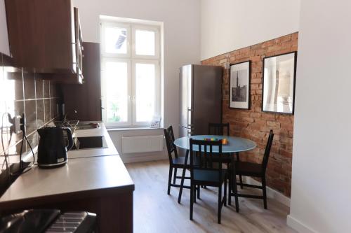 a kitchen with a table and chairs and a refrigerator at Apartments Old Town Gdansk - Toruńska 26 in Gdańsk